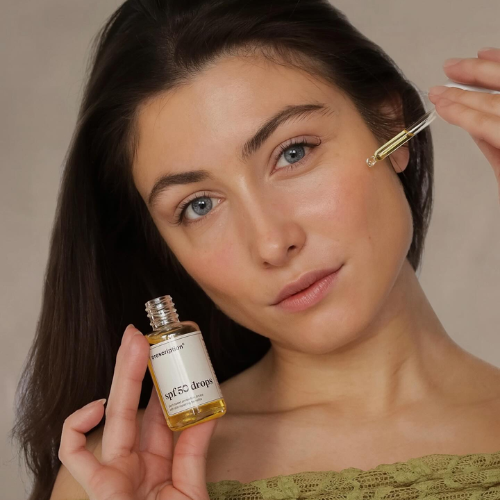 Model gebruikt Prescription Skincare SPF 50 drops met pipet voor zonbescherming